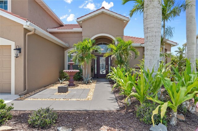 7626 Double Pine Dr, Sarasota, FL 34240 - doorway to property featuring stucco siding and a tile roof