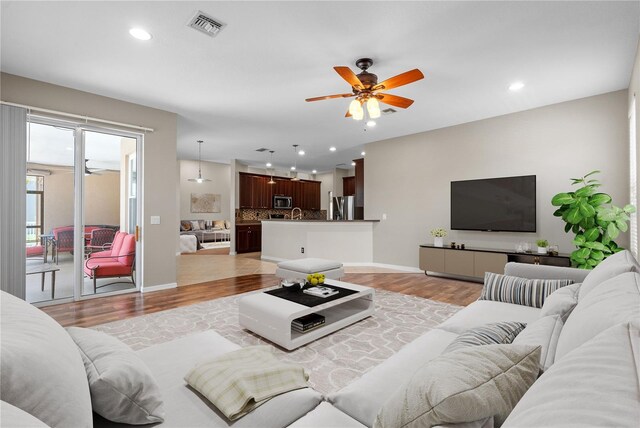 7626 Double Pine Dr, Sarasota, FL 34240 - living room featuring light wood-style floors, a ceiling fan, recessed lighting, and baseboards