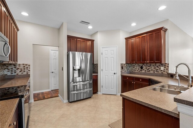 7626 Double Pine Dr, Sarasota, FL 34240 - kitchen with appliances with stainless steel finishes, a sink, tasteful backsplash, a peninsula, and recessed lighting