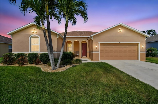 single story home with stucco siding, a yard, concrete driveway, and a garage