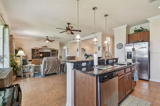 kitchen featuring appliances with stainless steel finishes, a sink, a ceiling fan, open floor plan, and dark stone counters