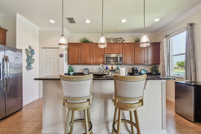 kitchen featuring stainless steel appliances, an island with sink, a kitchen breakfast bar, baseboards, and recessed lighting