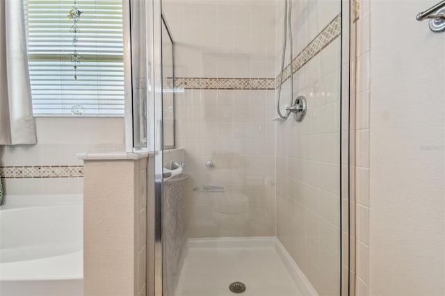 full bath with a stall shower and a garden tub