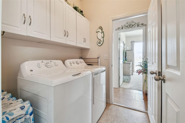 laundry area with independent washer and dryer and cabinet space