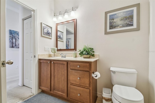 bathroom with vanity, toilet, and baseboards
