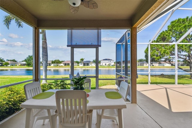 sunroom / solarium featuring a water view, a ceiling fan, and plenty of natural light