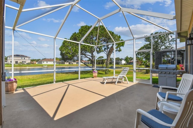view of patio featuring a water view, area for grilling, glass enclosure, and a residential view