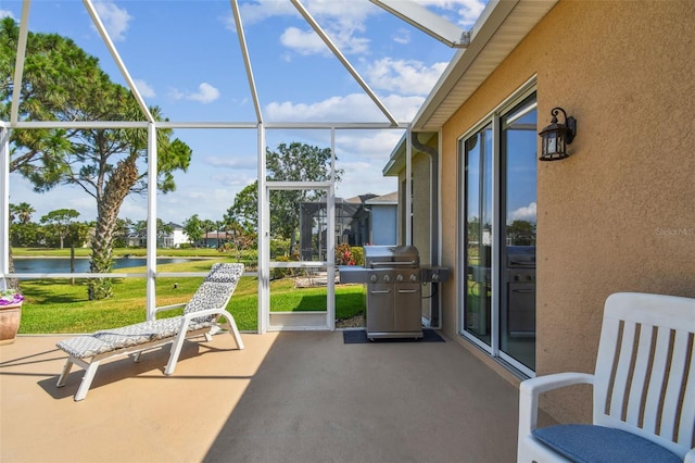 sunroom featuring a water view