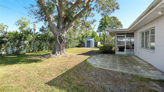 view of yard featuring a storage unit, a sunroom, a patio, and an outdoor structure