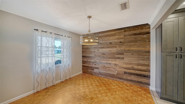 5706 10th Avenue Dr W, Bradenton, FL 34209 - unfurnished room with wooden walls, a chandelier, baseboards, and a textured ceiling