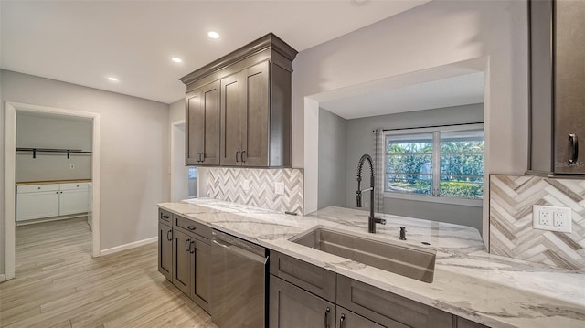 5706 10th Avenue Dr W, Bradenton, FL 34209 - kitchen with dishwasher, a sink, tasteful backsplash, light wood-type flooring, and light stone countertops