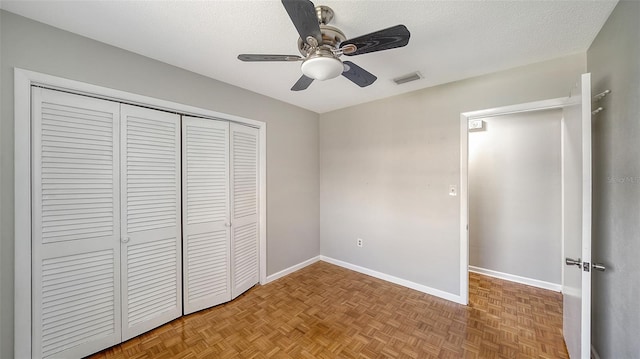 5706 10th Avenue Dr W, Bradenton, FL 34209 - unfurnished bedroom featuring a closet, baseboards, a textured ceiling, and ceiling fan