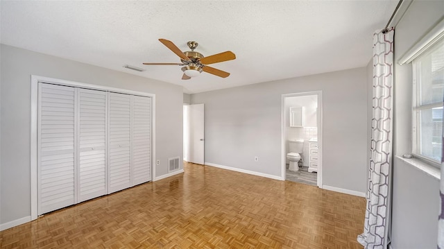 5706 10th Avenue Dr W, Bradenton, FL 34209 - unfurnished bedroom featuring baseboards, a closet, a textured ceiling, connected bathroom, and ceiling fan