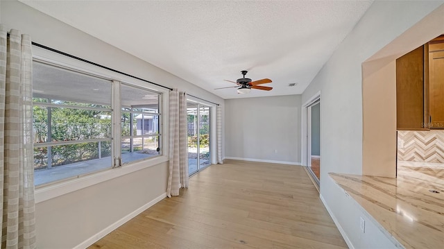 5706 10th Avenue Dr W, Bradenton, FL 34209 - unfurnished room with baseboards, a ceiling fan, light wood-style floors, and a textured ceiling