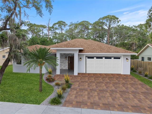 view of front facade featuring stucco siding, a garage, roof with shingles, and decorative driveway