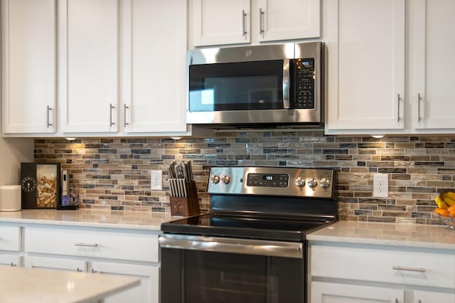 910 Tidewater Shores Loop Unit 103, Bradenton, FL 34208 - kitchen featuring stainless steel appliances, tasteful backsplash, and white cabinets