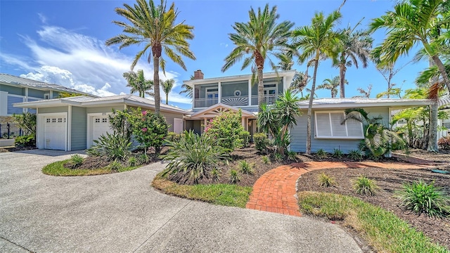 878 Freeling Dr, Sarasota, FL 34242 - view of front of home featuring driveway, an attached garage, a chimney, and a balcony