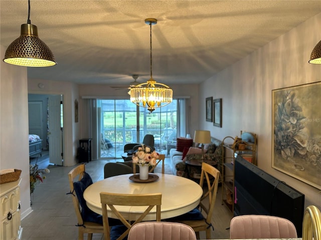 dining space with a textured ceiling, a chandelier, and a ceiling fan