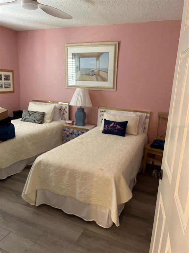 bedroom with wood finished floors, a ceiling fan, and a textured ceiling