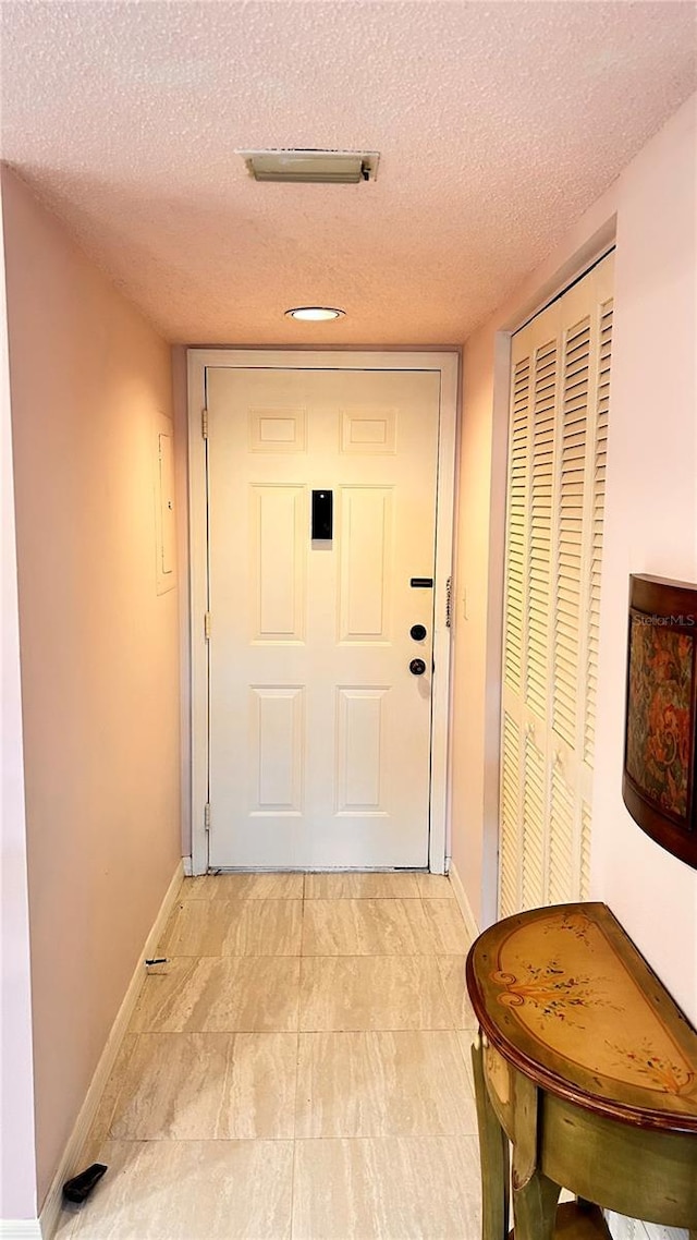 433 Cerromar Ln Unit 331, Venice, FL 34293 - doorway to outside featuring a textured ceiling and baseboards