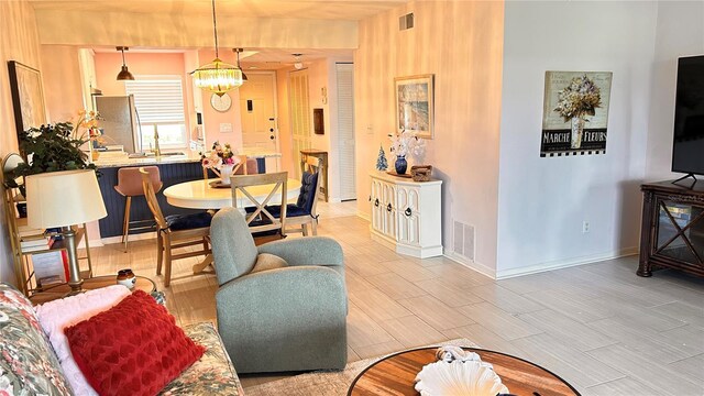 433 Cerromar Ln Unit 331, Venice, FL 34293 - living room featuring a chandelier and baseboards