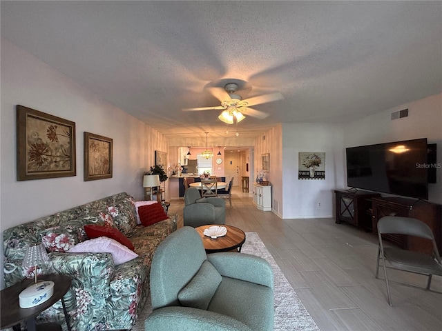 433 Cerromar Ln Unit 331, Venice, FL 34293 - living area featuring a ceiling fan, a textured ceiling, and light wood-style flooring