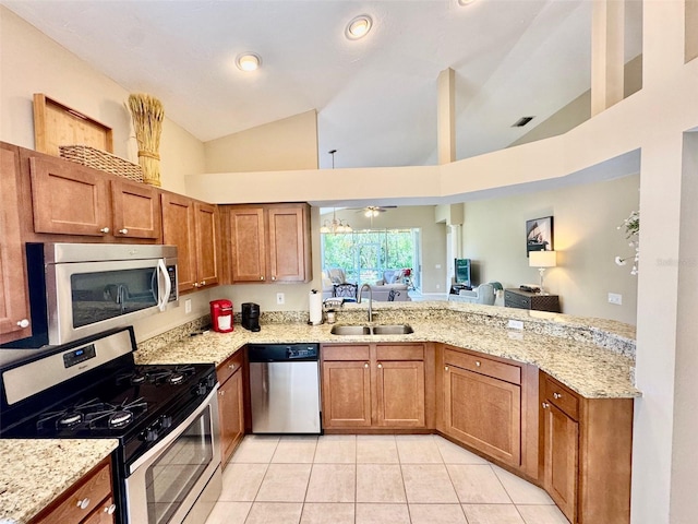 kitchen with appliances with stainless steel finishes, a sink, light tile patterned flooring, brown cabinetry, and high vaulted ceiling