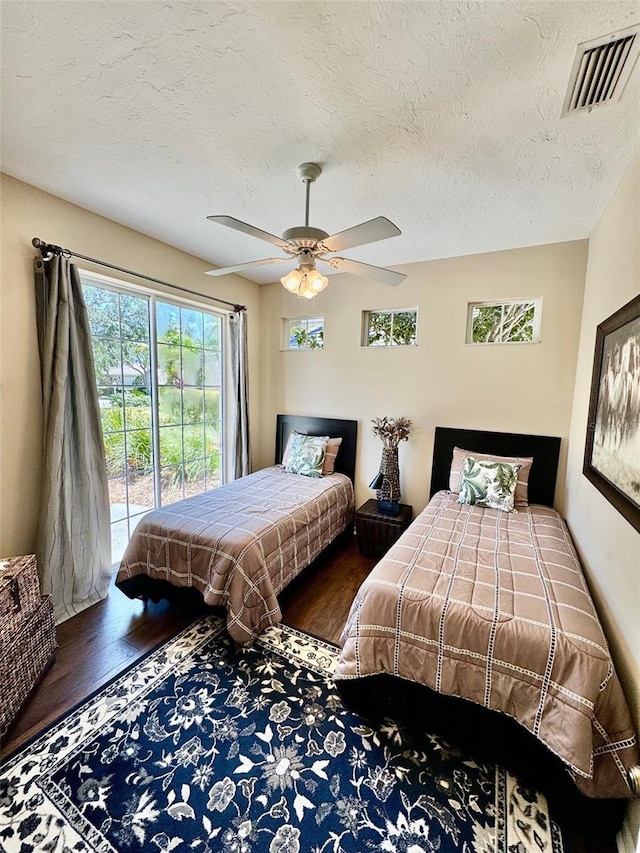 bedroom featuring access to outside, wood finished floors, ceiling fan, and a textured ceiling