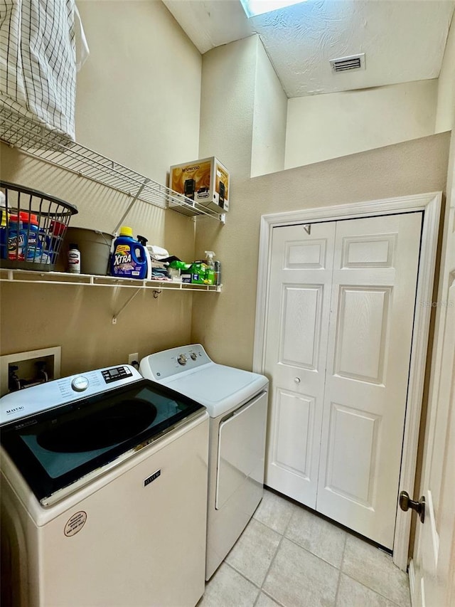 laundry room with separate washer and dryer and light tile patterned floors