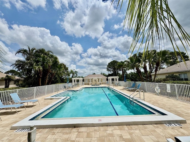 community pool with fence and a patio area