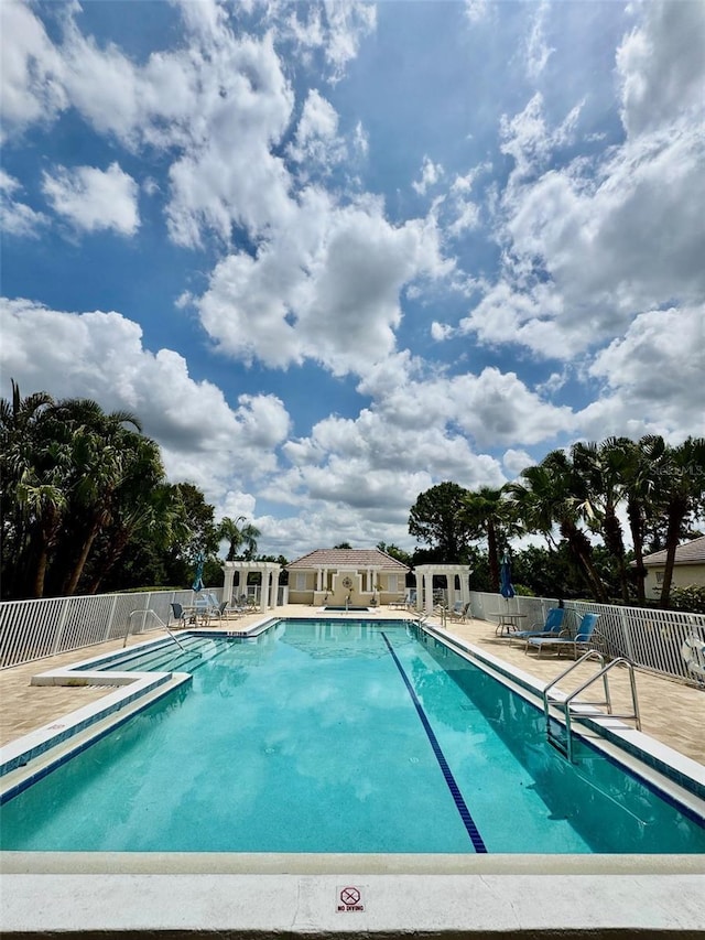 community pool featuring fence and a patio area