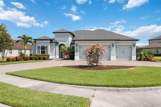 view of front facade with concrete driveway, stucco siding, a garage, and a front yard