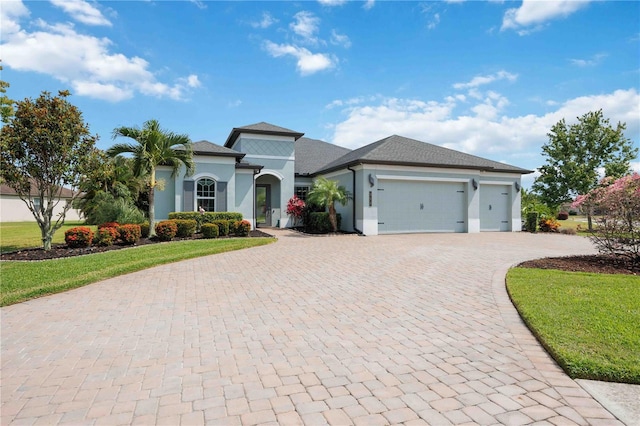 mediterranean / spanish home with decorative driveway, an attached garage, stucco siding, and a front lawn