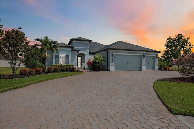 mediterranean / spanish home with an attached garage, decorative driveway, and stucco siding