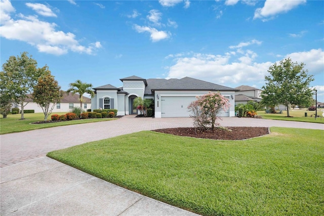 mediterranean / spanish house with curved driveway, a front yard, an attached garage, and stucco siding