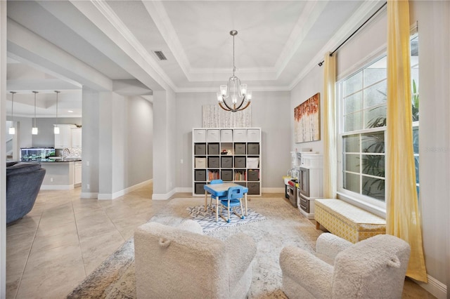 living area with a tray ceiling, a chandelier, ornamental molding, and baseboards