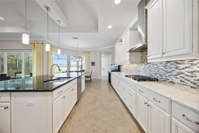 kitchen featuring a sink, appliances with stainless steel finishes, decorative backsplash, wall chimney range hood, and recessed lighting
