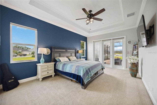 bedroom featuring a tray ceiling, access to outside, carpet, crown molding, and baseboards