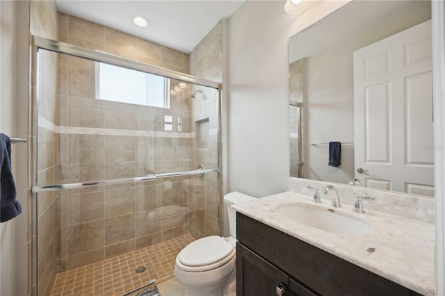 full bathroom with toilet, a stall shower, and vanity