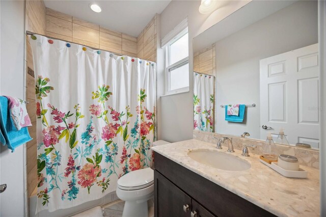 bathroom featuring curtained shower, toilet, and vanity
