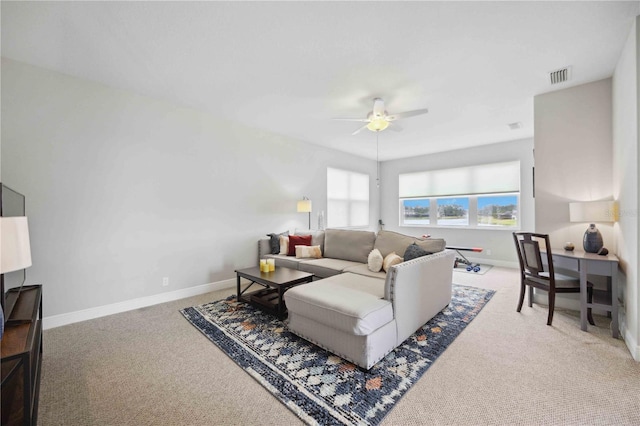 living area with carpet floors, a ceiling fan, and baseboards