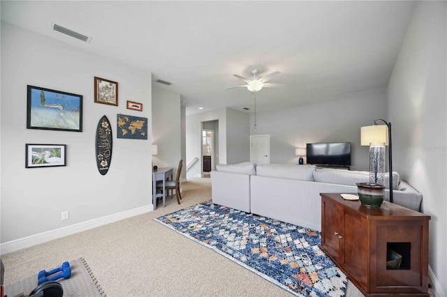 carpeted living room featuring ceiling fan and baseboards