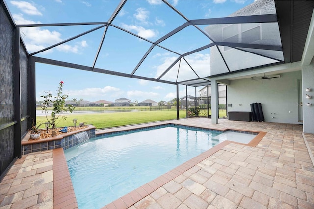 swimming pool with a patio, a lawn, a water view, ceiling fan, and glass enclosure