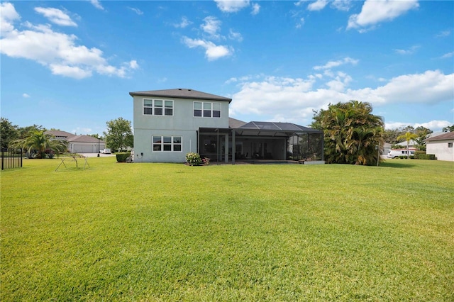 rear view of property featuring a yard, stucco siding, and a lanai