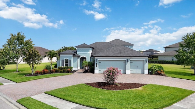 view of front of property featuring stucco siding, a garage, driveway, a front lawn, and a shingled roof