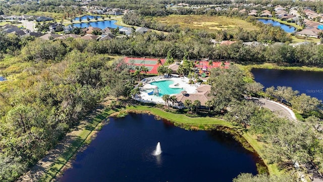 aerial view of property's location featuring a large body of water, a pool, and nearby suburban area
