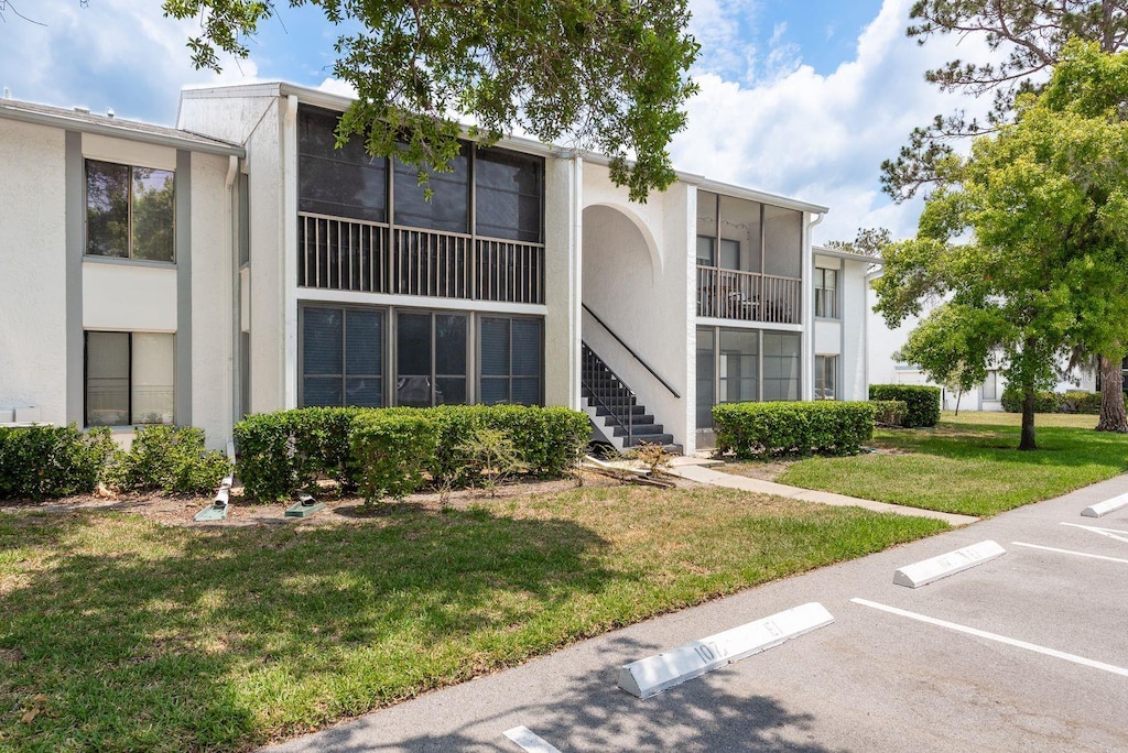 1151 Pine Ridge Cir W Unit H1, Tarpon Springs, FL 34688 - view of building exterior with uncovered parking and stairs