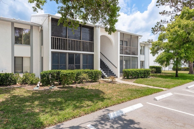 1151 Pine Ridge Cir W Unit H1, Tarpon Springs, FL 34688 - view of building exterior with uncovered parking and stairs