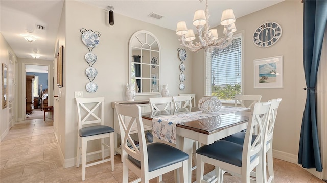 dining area with a chandelier and baseboards