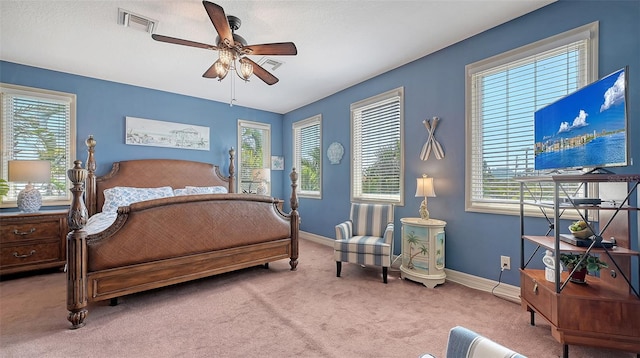 carpeted bedroom with multiple windows, baseboards, and a ceiling fan